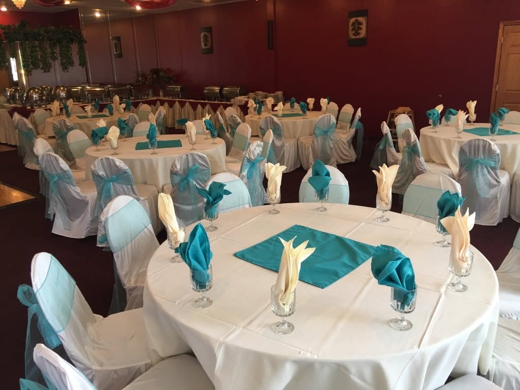 Banquet hall set with round tables and teal sashes at Taste of India, Willowbrook IL